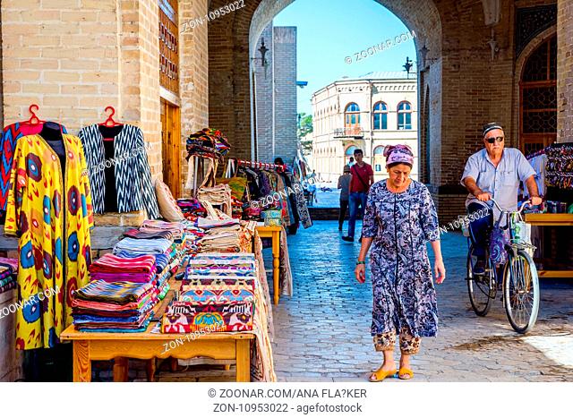 BUKHARA, UZBEKISTAN - SEPTEMBER 4: Street bazaar with souvenirs and traditional uzbek clothes in Bukhara downtown. September 2016