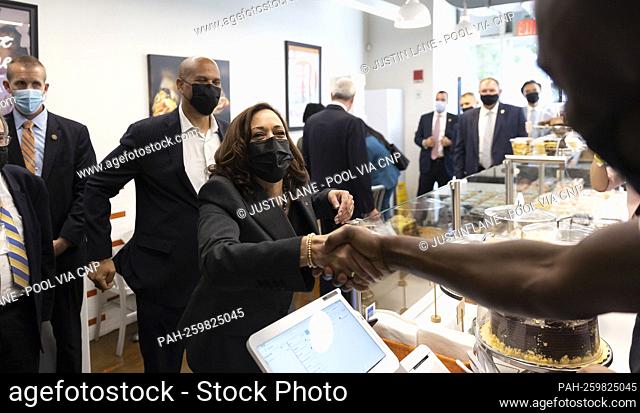 U.S. Vice President Kamala Harris (C) shakes hands with Tonnie Rozier (R), the owner of the bakery Tonnie’s Minis while standing with US Senator Cory Booker...