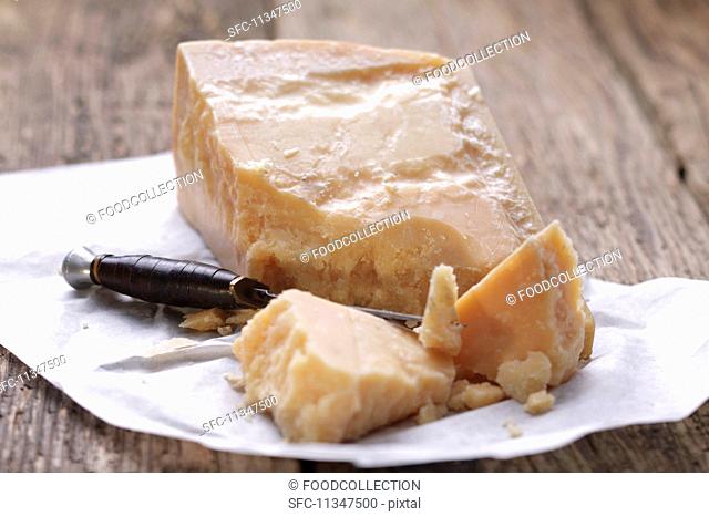 Parmesan with a cheese knife on a piece of paper
