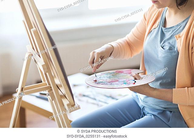 artist with palette knife painting at art studio