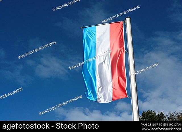 13 October 2023, Luxembourg, Vianden: The national flag of the Grand Duchy of Luxembourg flies in the wind against a blue sky