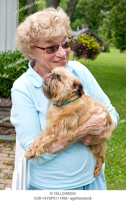 mature woman hugging her brussels griffon dog