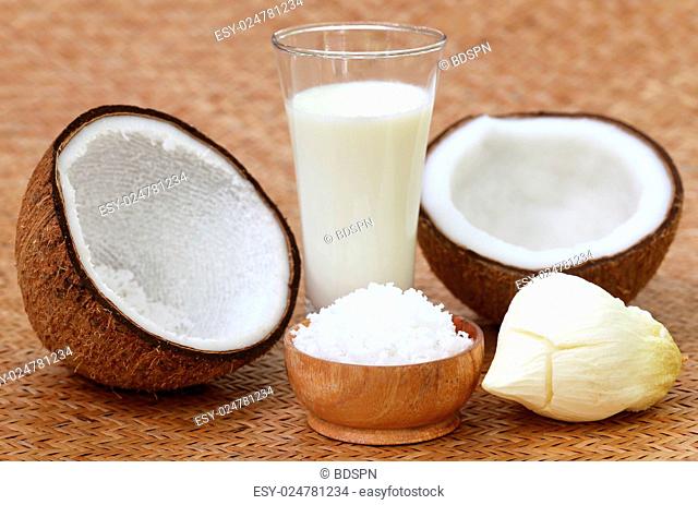 Fresh Coconut with milk in a glass on textured surface