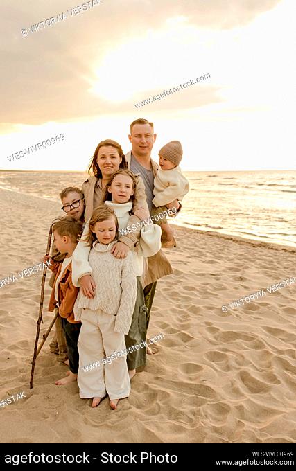 Happy family standing together at beach