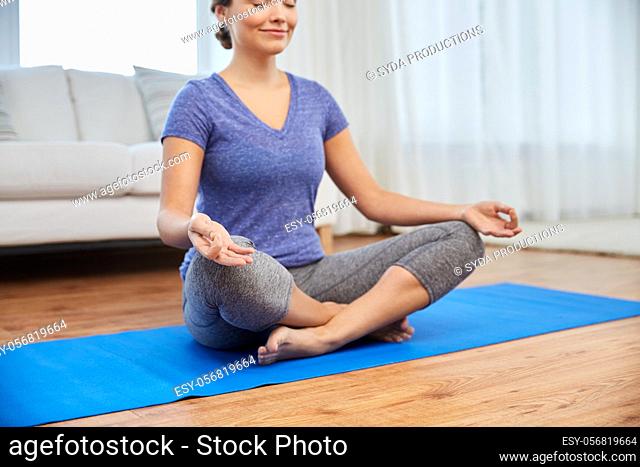 woman meditating in lotus pose at home
