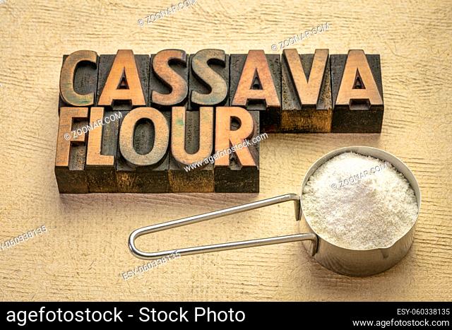 Cassava (yuca) flour in a measuring scoop with a text in vintage wood type. scoop. It is a gluten free and grain free replacement for wheat flour