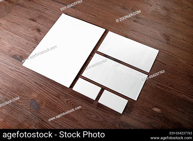 Photo of blank stationery set on wood background. Envelope, business cards and letterhead. Corporate identity template. Responsive design mockup