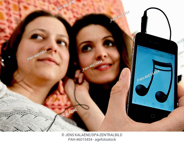 ILLUSTRATION - Two young women listen to music from their smartphone in Berlin, Germany, 25 January 2014. Photo: Jens Kalaene - MODEL RELEASED | usage worldwide