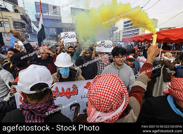 10 January 2020, Iraq, Baghdad: An anti-government demonstrator holds a flare during a demonstration in Tahrir square, against the breach of Iraqi sovereignty...