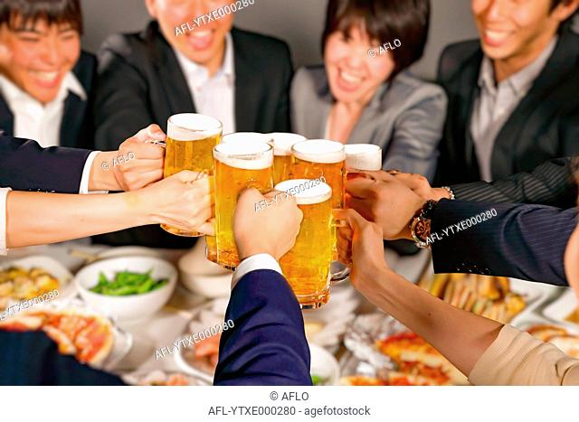 Group of young Japanese friends toasting with beer