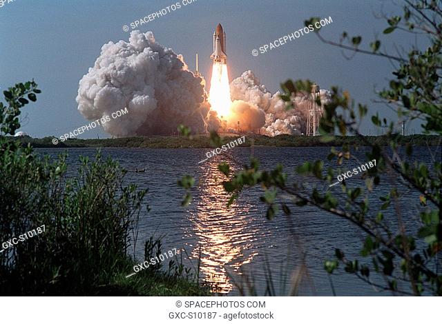 04/08/2002 - As Space Shuttle Atlantis roars into the sky on mission STS-110, flames from the solid rocket boosters light up the water near Launch Pad 39B