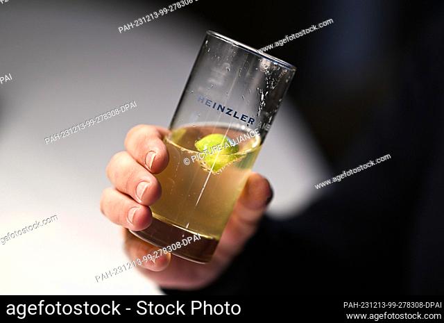 12 December 2023, Baden-Württemberg, Immenstaad am Bodensee: Michael Heinzler from Hotel and Restaurant Heinzler am See holds a glass in his hand during an...