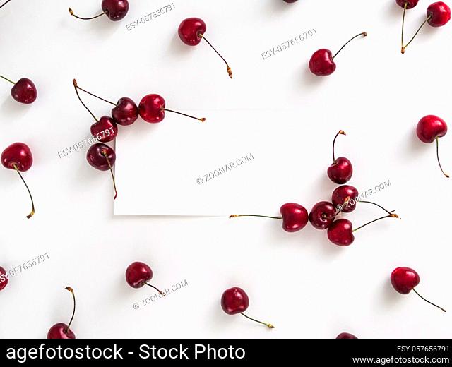 Creative layout with fresh ripe berries. Cherry isolated on white background with white rectangle for copy space. Can use for your design, promo, social media