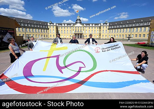 25 August 2022, Baden-Wuerttemberg, Karlsruhe: A flag is presented in front of the castle for the 11th Assembly of the World Council of Churches