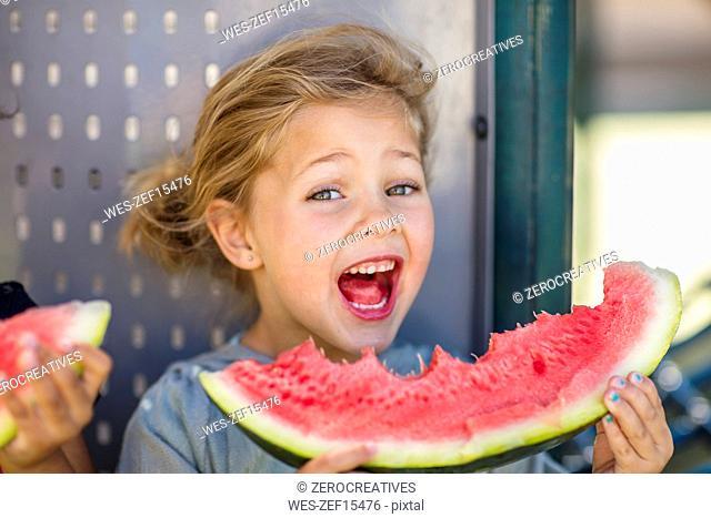 Portrait of happy girl eating a watermelon in kindergarten