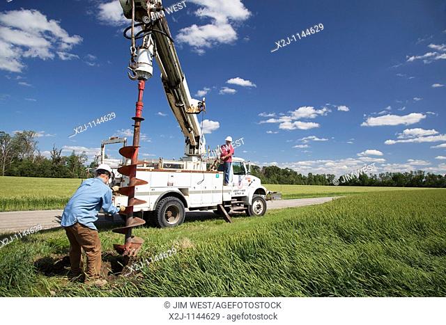 Dundee, Michigan - Electrical workers use a truck-mounted auger to dig a hole for a new utility pole to replace one destroyed by a tornado