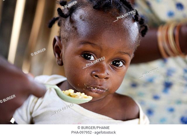 Child suffering from malnutrition tasting a rice-based ordinary meal. Therapeutic Feeding Center in Monrovia, Liberia, implemented by Action contre la Faim ACF