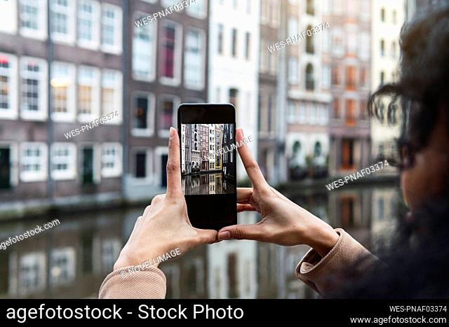 Young woman photographing city through smart phone