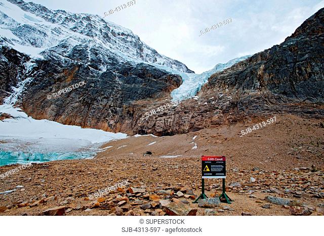 A sign warns of the dangers of approaching Angel Glacier, where chunks of ice calve from the melting glacier at the base of Mount Edith Cavell