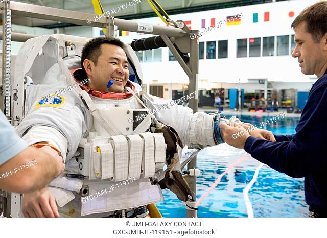 Japan Aerospace Exploration Agency (JAXA) astronaut Akihiko Hoshide, Expedition 3233 flight engineer, dons a training version of his Extravehicular Mobility...