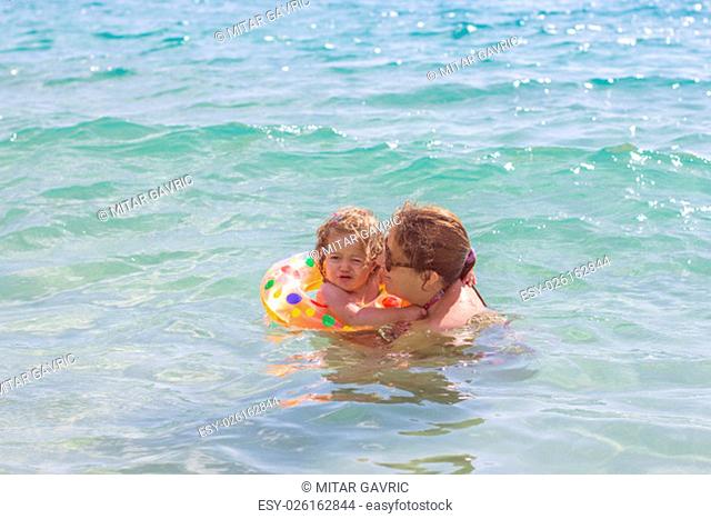 Young Mother and her little girl have fun in the beautiful turquese sea on summer day. Travel Vacation lifestyle