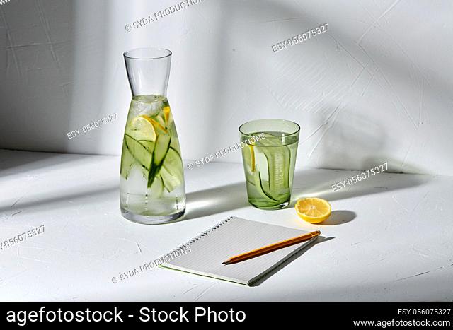 water with lemon and cucumber and notebook