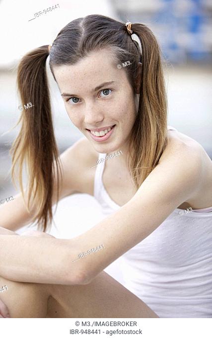 17 year-old girl with her hair in ponytails, smiling