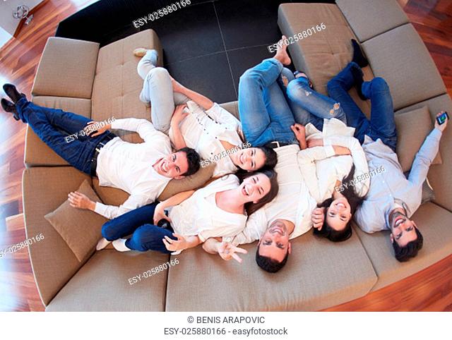 portrait of happy young group of friends get releax and have fun at modern home interior, top view