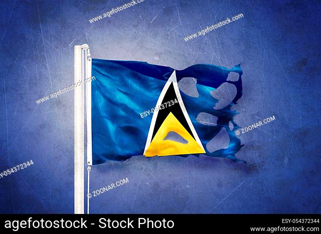 Torn flag of Saint Lucia flying against grunge background