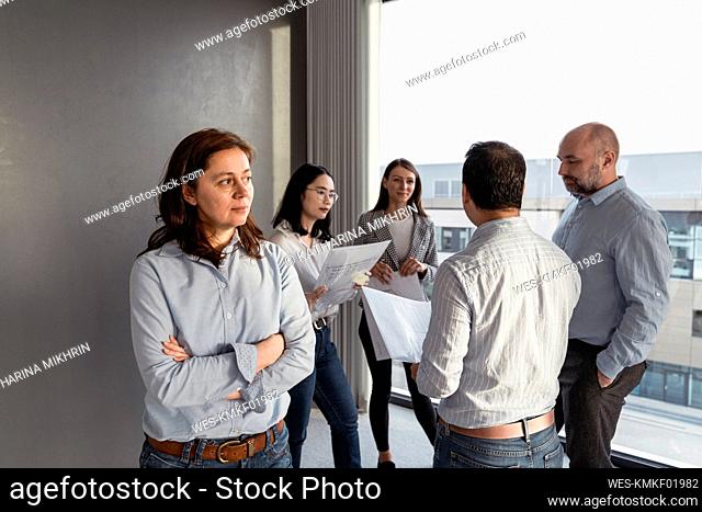 Thoughtful businesswoman with colleagues working on an architectural project in office