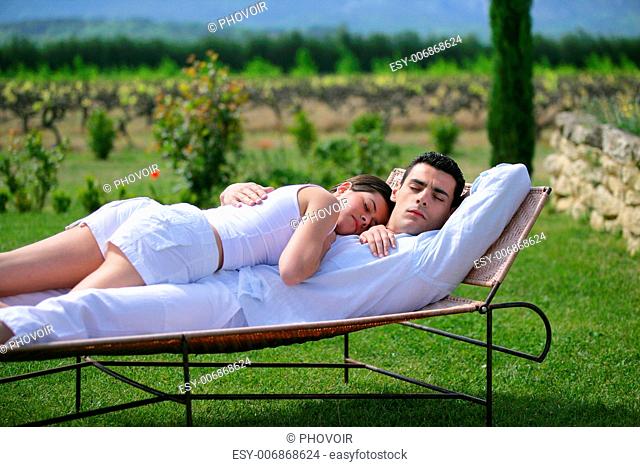 Couple having a nap on sun lounger