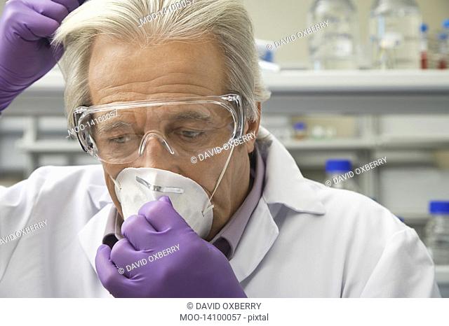 Scientist putting on safety mask in laboratory