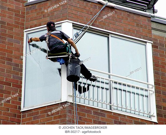 USA, United States of America : Window cleaner, abseiling from the roof to each floor