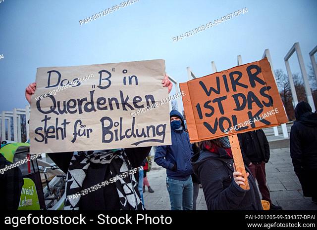 05 December 2020, Mecklenburg-Western Pomerania, Schwerin: Counter-demonstrators stand with their signs (""The B in Querdenken stands for education""