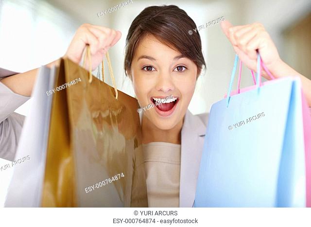 Happy excited woman holding up her shopping bags
