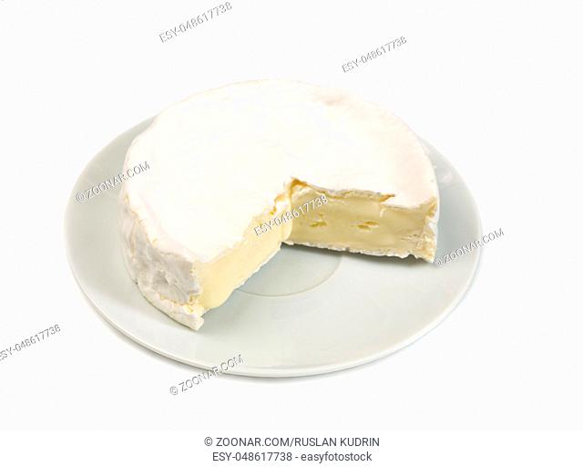 Round camembert cheese with a cut out piece isolated on white