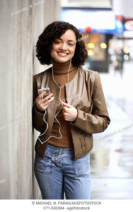 Hispanic woman listening to her Ipod on street