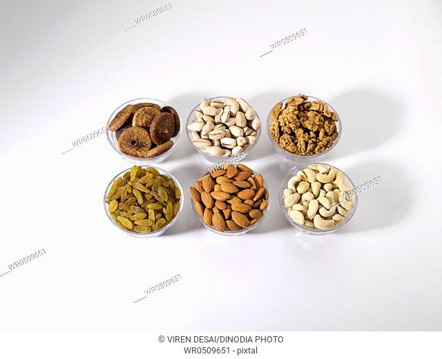 Dryfruit and nut , almonds raisins cashewnuts figs pistachios walnuts in bowls on white background