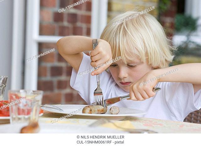 boy eating with knife and fork