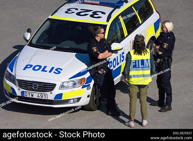 Stockholm, Sweden A police dispatch car and officers speaking with a a member of a film crew