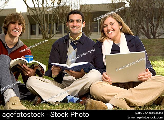 Three students sat outdoors