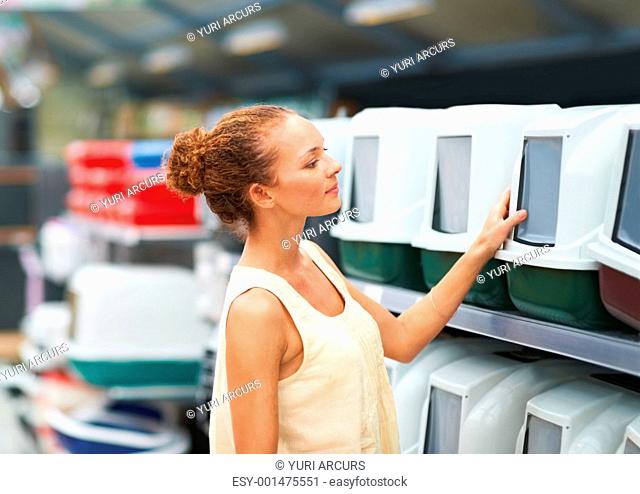 Portrait of woman selecting cat cages at petshop
