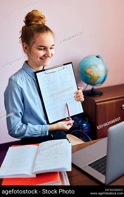 Young woman student showing homework, having classes, learning online, watching lesson remotely, listening to professor, talking with classmates on video call...