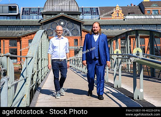 31 August 2021, Hamburg: Green Party leader Anton Hofreiter (r) and Hamburg's ex-Justice Senator Till Steffen (Bündnis 90/Die Grünen) walk across a bridge at...