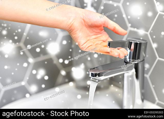 close up of woman's hand opening water tap