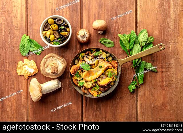 A rustic mushrooms and olives saute with mint, shot from the top with copy space