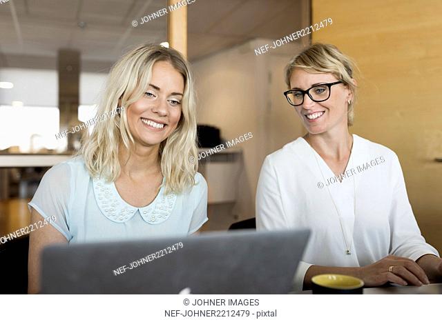 Businesswomen looking at laptop