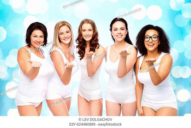 love, friendship, beauty, body positive and people concept - group of happy plus size women in white underwear sending blow kiss over blue holidays lights...