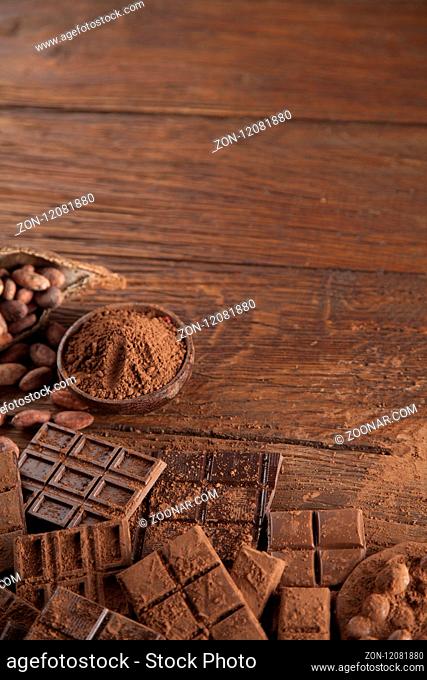 Dark homemade chocolate bars and cocoa pod on wooden