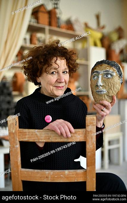 05 March 2020, Berlin: The artist Rachel Kohn holds a mask in her studio, which shows the face of the late artist Edith Kramer